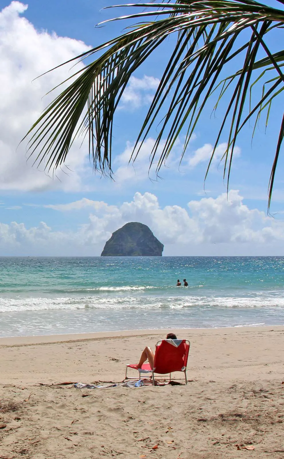 Person on a red chair in front of Diamond Rock